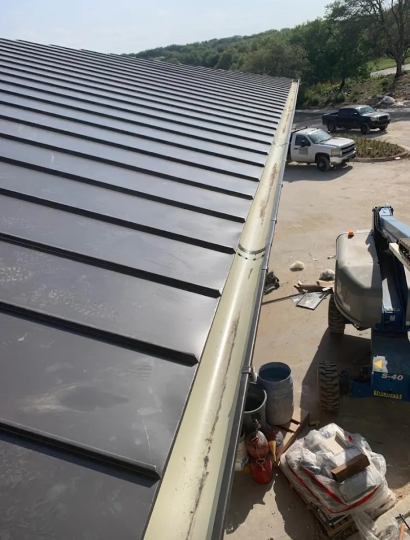 Standing seam panel and gutter detail on a metal roofing jobsite in Marcellus